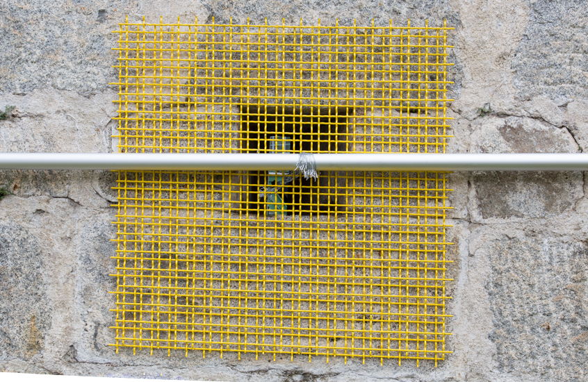 Encage, 2016, flag pole, metal mesh, metal wire, wood, 700 x 100 cm.