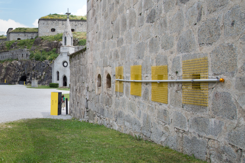 Encage, 2016, flag pole, metal mesh, metal wire, wood, 700 x 100 cm.